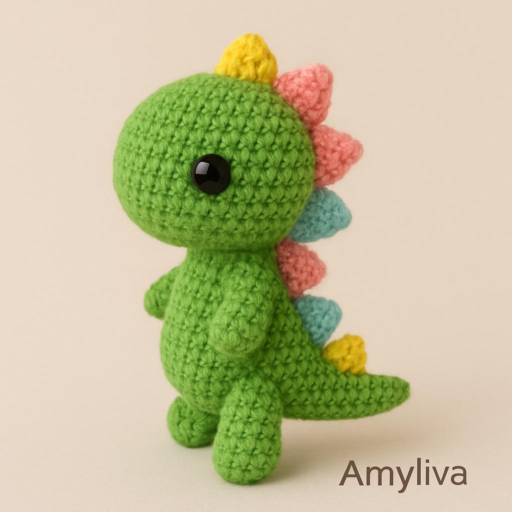 Colorful handmade mini amigurumi dinosaur crocheted with green and yellow yarn, perfect for beginners and displayed on a white background.