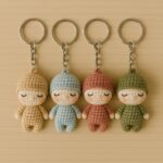 Handmade crochet baby keychains – adorable miniature dolls with sleeping face details, crafted in soft pastel colors. Each baby features a unique outfit and is attached to a metal keyring. Perfect for craft lovers and personalized gifts!