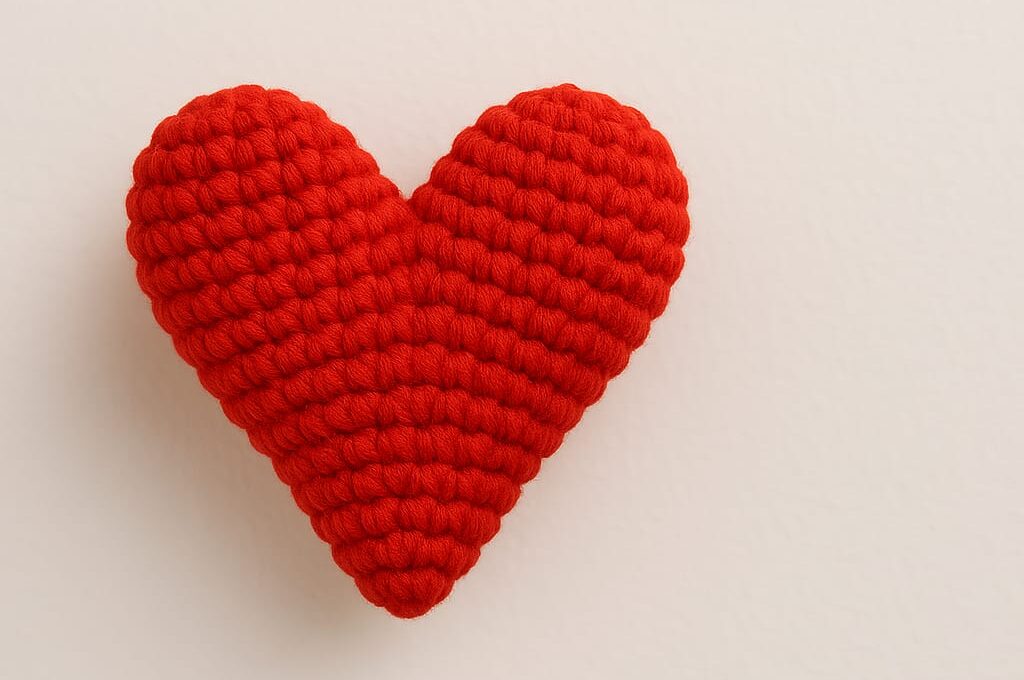 Close-up of a handmade amigurumi heart made with red yarn