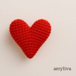 Close-up of a handmade amigurumi heart made with red yarn