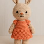 "Cute organic amigurumi rabbit toy from AMYLIVA, wearing a peach-colored dress, perfect handmade gift for babies and kids."