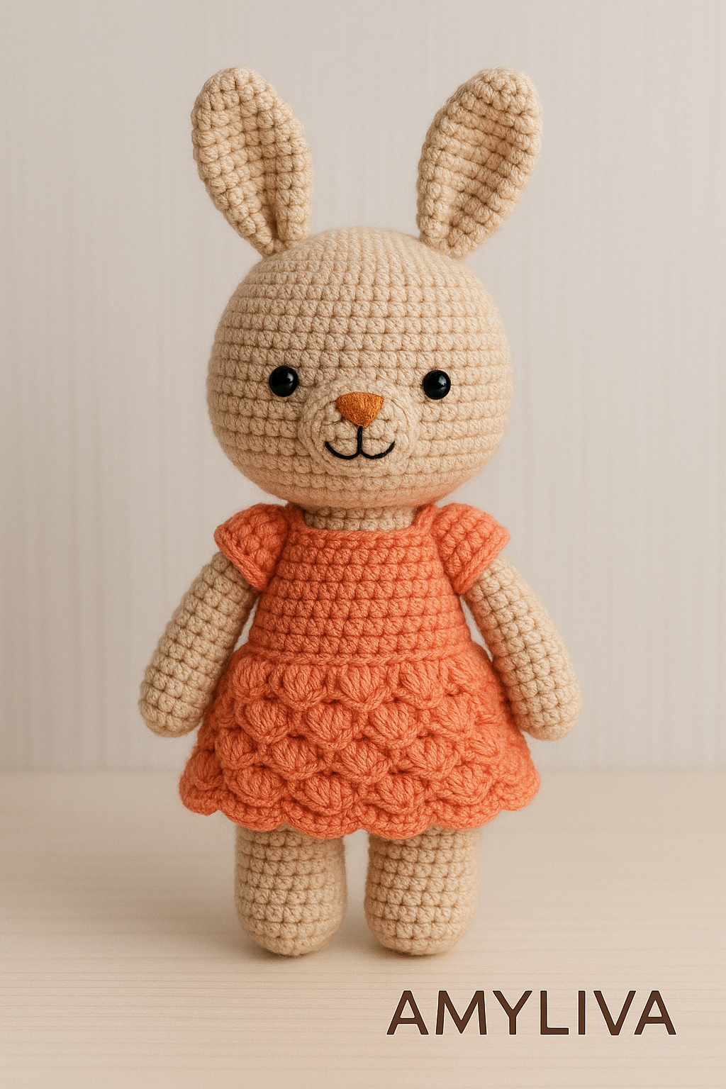 "Cute organic amigurumi rabbit toy from AMYLIVA, wearing a peach-colored dress, perfect handmade gift for babies and kids."