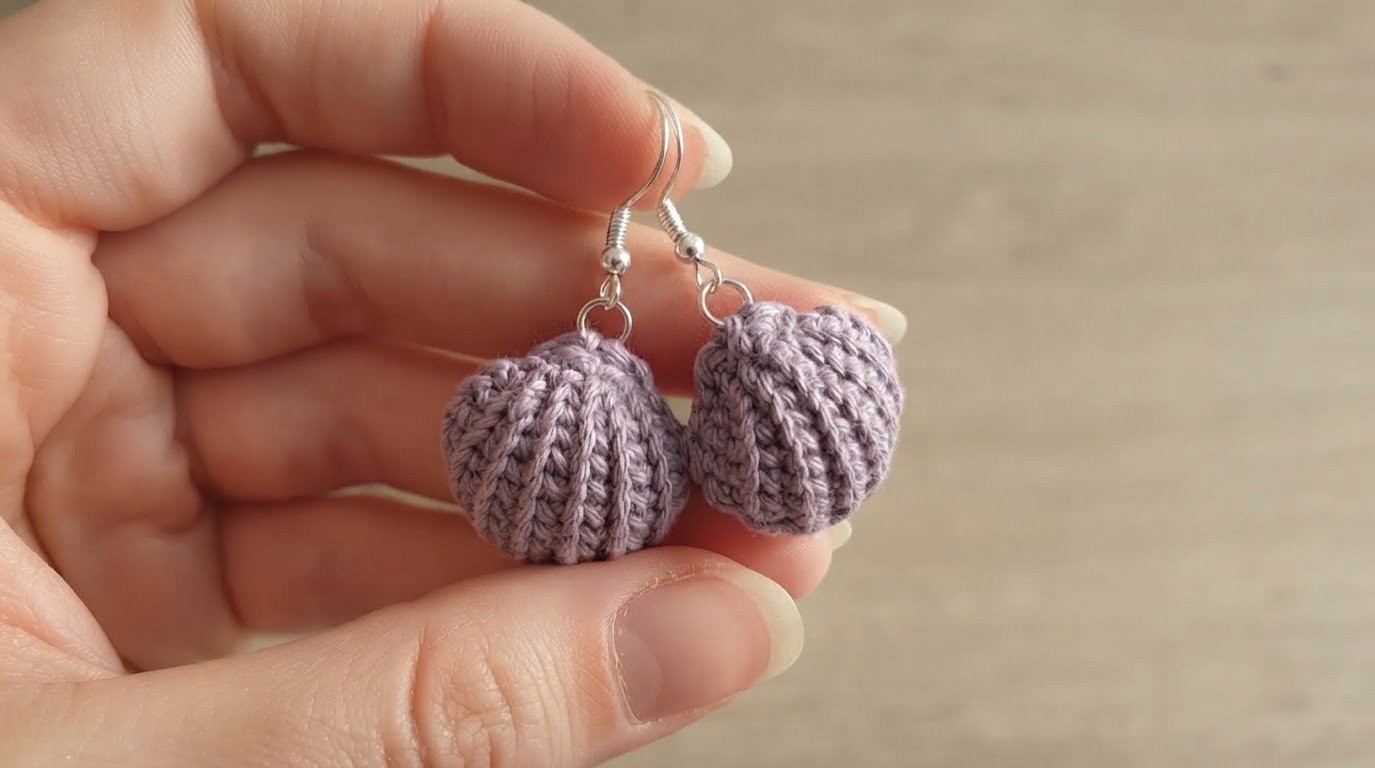 ⁠handmade crochet lilac seashell earrings held in hand⁠
